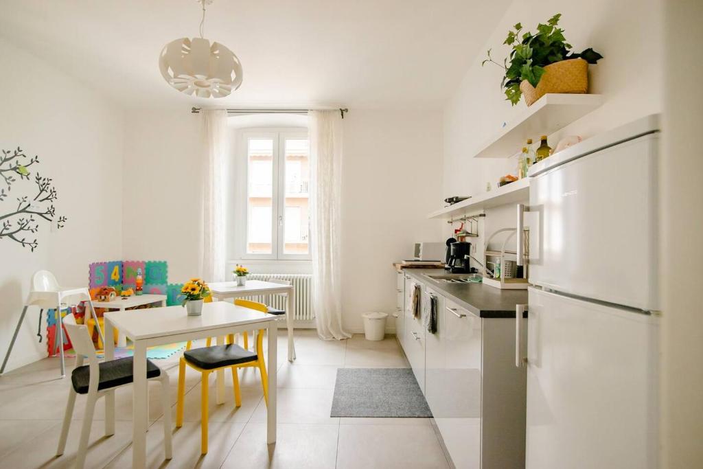 贝加莫Guesthouse Tree Rooms Modern的带小桌子的厨房和带白色家电的厨房