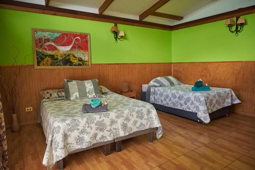安加罗阿Cabañas Maria Hau的绿墙客房内的两张床