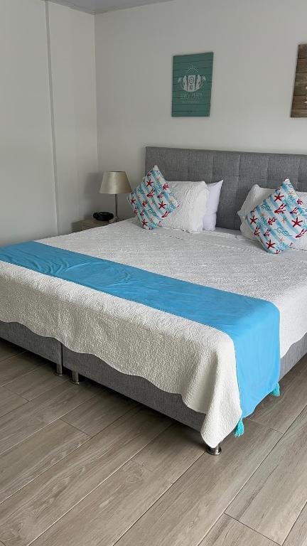 圣安德烈斯Hotel Mar de Corales By CAJASAI的一张配有蓝色床单和枕头的大床