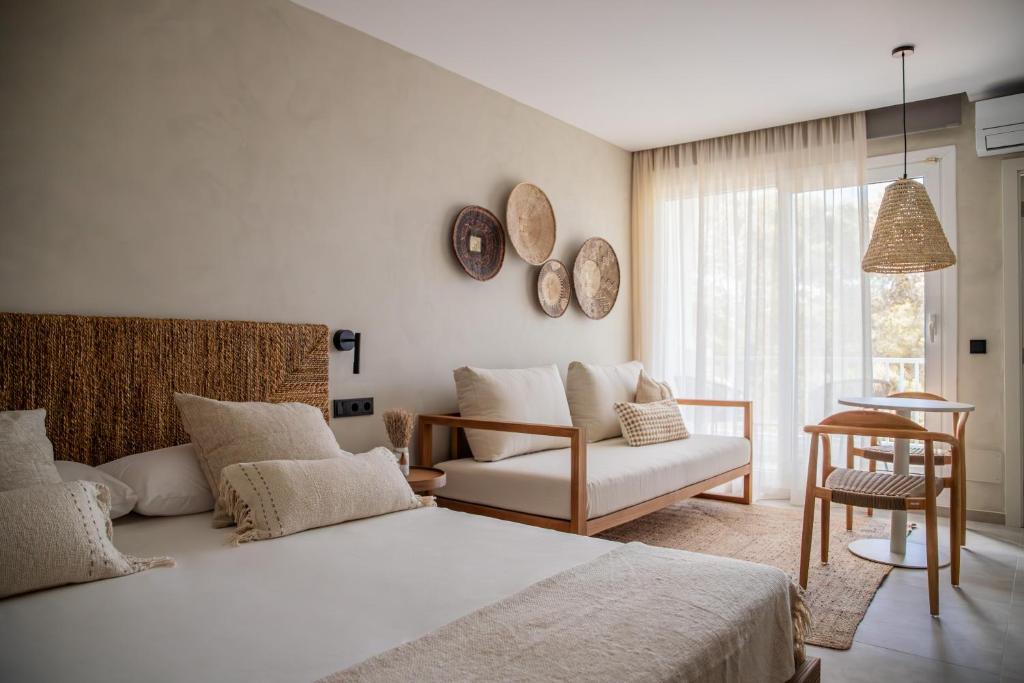 埃斯普霍斯Boho Suites Formentera的一间卧室配有一张床、一张沙发和一把椅子