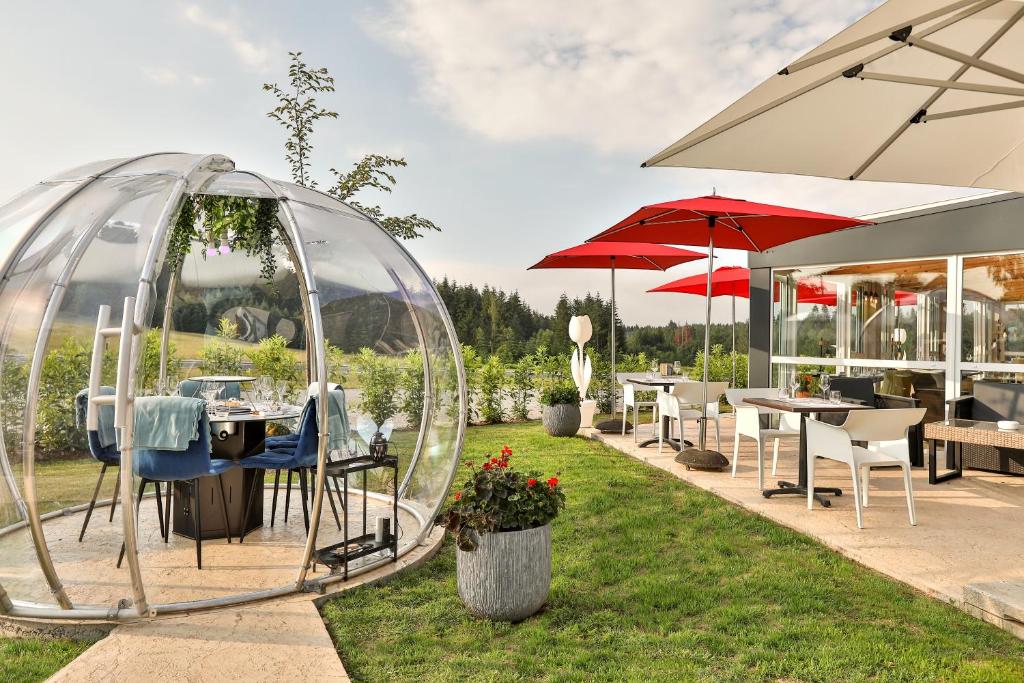 MaussacHôtel-Restaurant Logis Europa的一个带桌椅的气泡帐篷花园