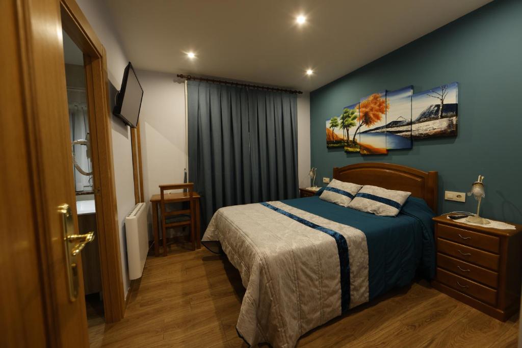 普韦布拉桑纳比亚LUZ DE PRADA的卧室配有一张床,墙上挂有绘画作品