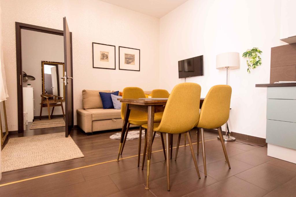 布达佩斯保洛伊精品公寓的一间带桌子和黄色椅子的用餐室