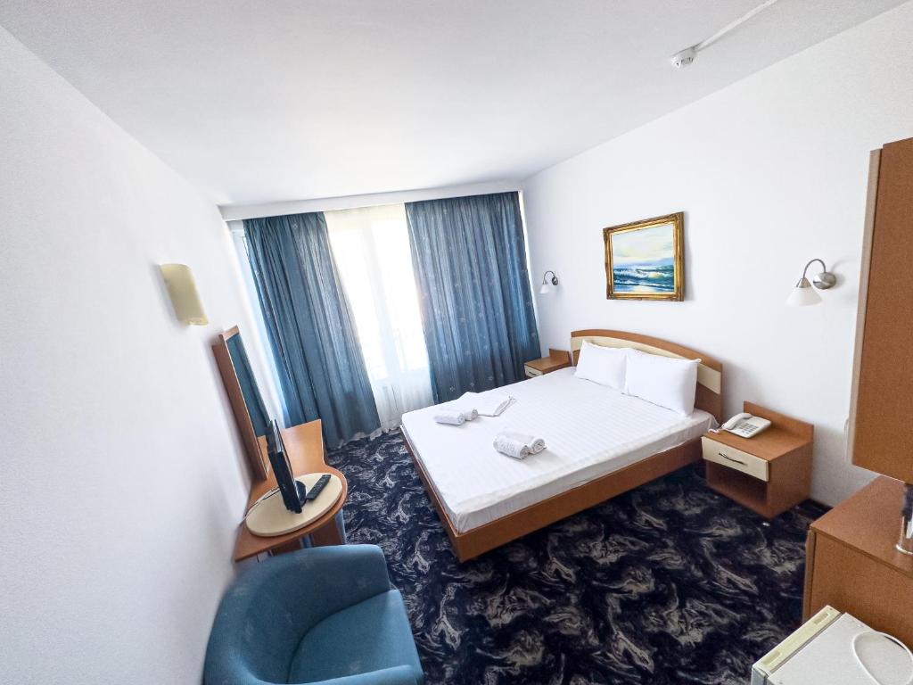 萨图恩塞雷纳酒店的酒店客房,配有一张床和一张蓝色椅子