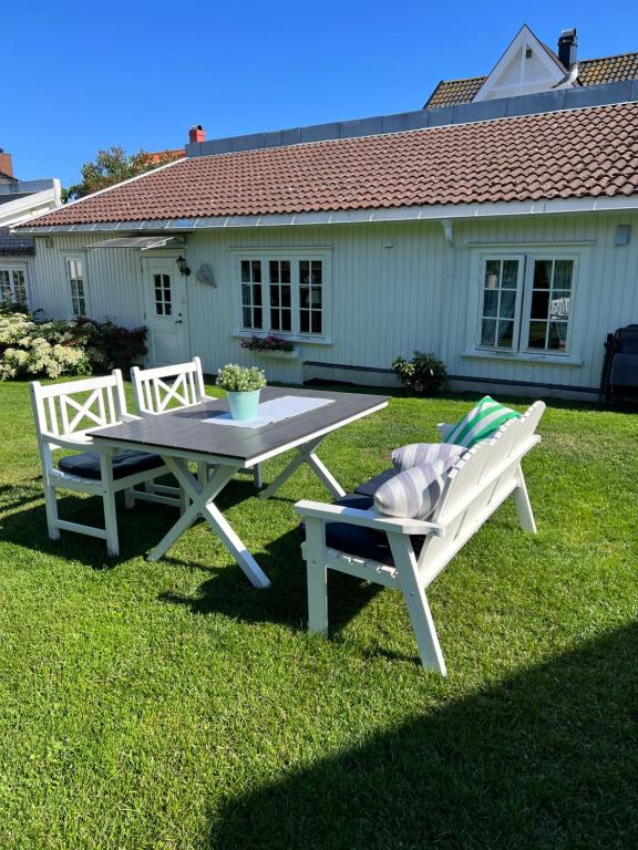 斯塔韦恩Koselig maritim leilighet sentralt i Stavern的院子里的一张野餐桌和两把椅子
