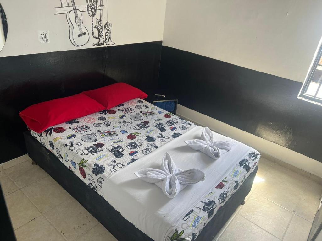 马尼萨莱斯El Amanecer La 27的一间卧室配有一张带白色床单和弓的床铺
