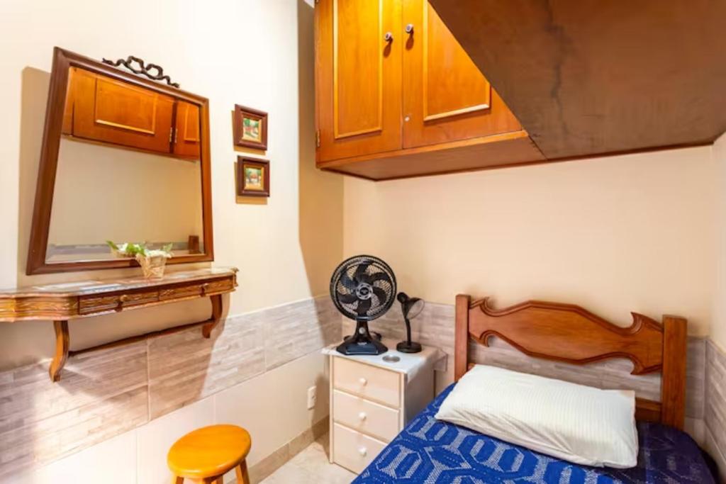 里约热内卢Quarto em casa de vila em Botafogo, Rio de Janeiro的一间小卧室,配有一张床和镜子
