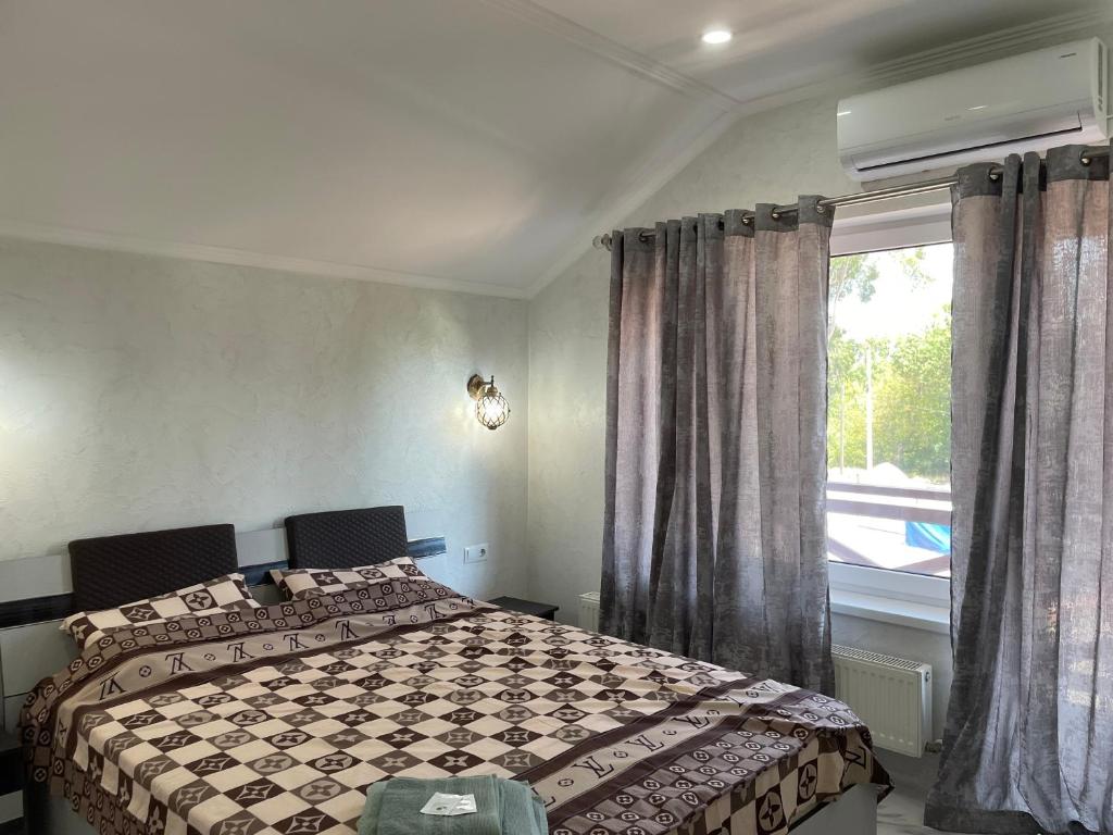 基希讷乌Villa aeroport розовый дом的一间卧室设有一张床和一个窗口
