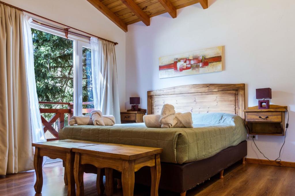 拉安戈斯图拉镇BOG Apart Foresta - A minutos del cerro bayo的一间卧室配有一张床、一张桌子和一个窗户。