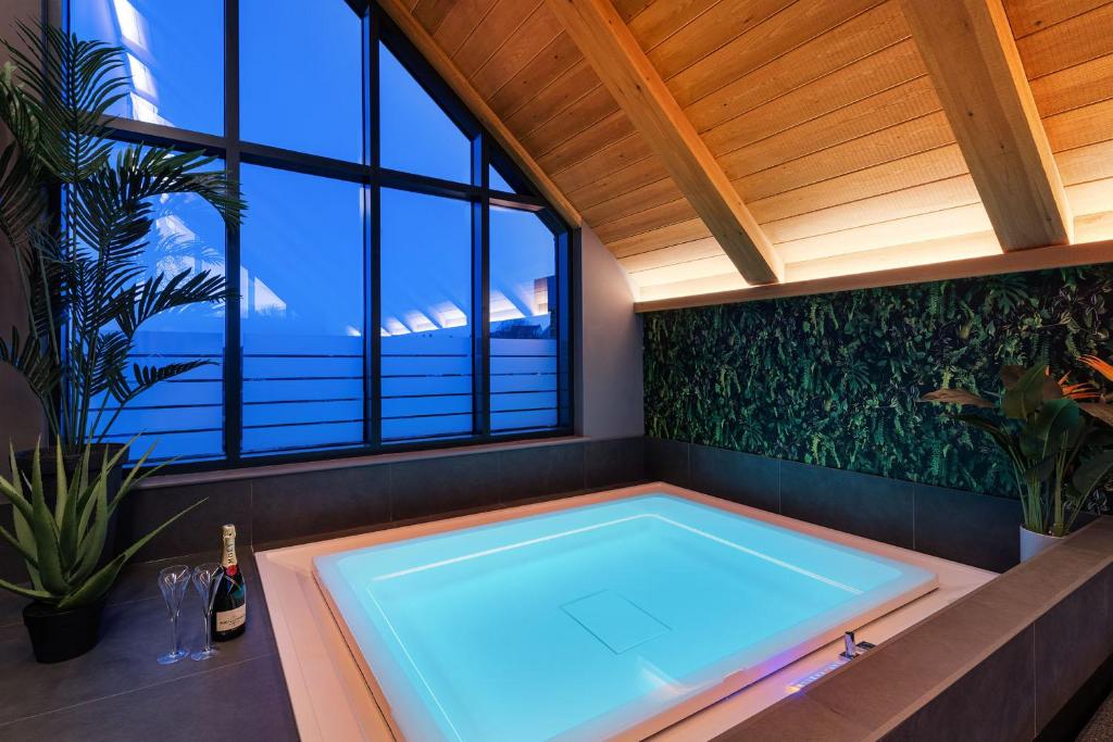 安布尔Marina West - Amble, Northumberland的带大窗户的客房内的热水浴池