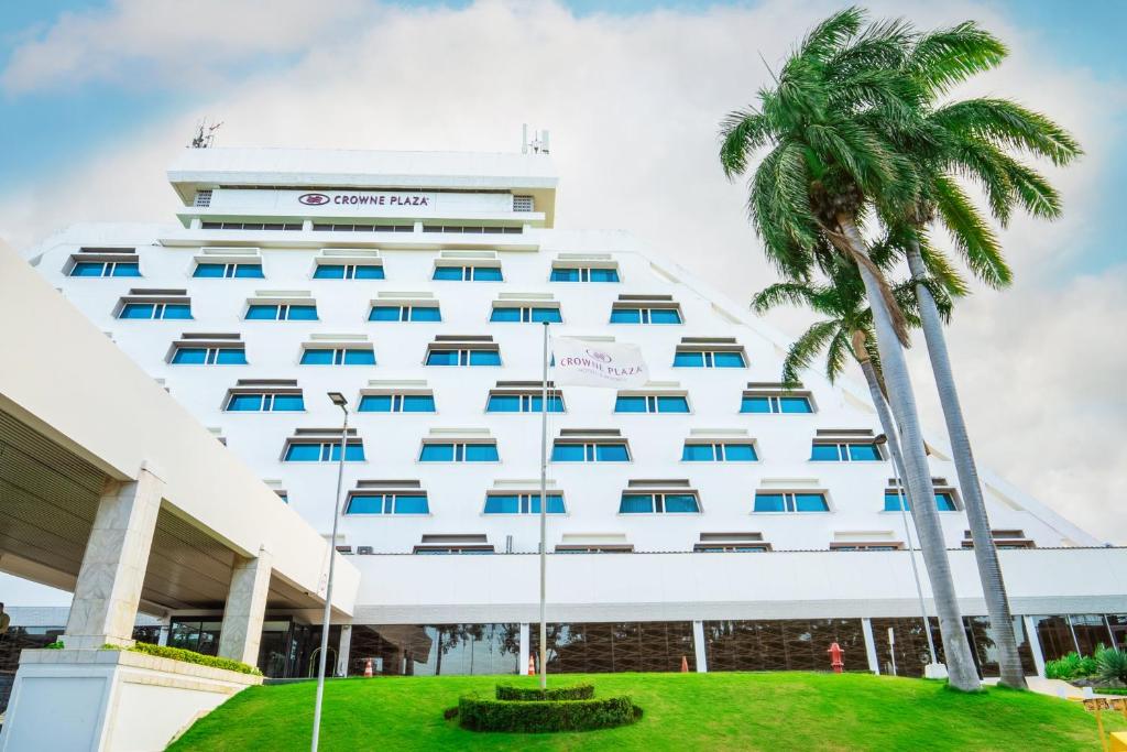 马那瓜马那瓜皇冠广场酒店的前面有棕榈树的酒店