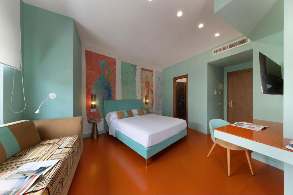 索伦托Sorrento Rooms Deluxe的一间卧室配有一张床、一张沙发和一张书桌