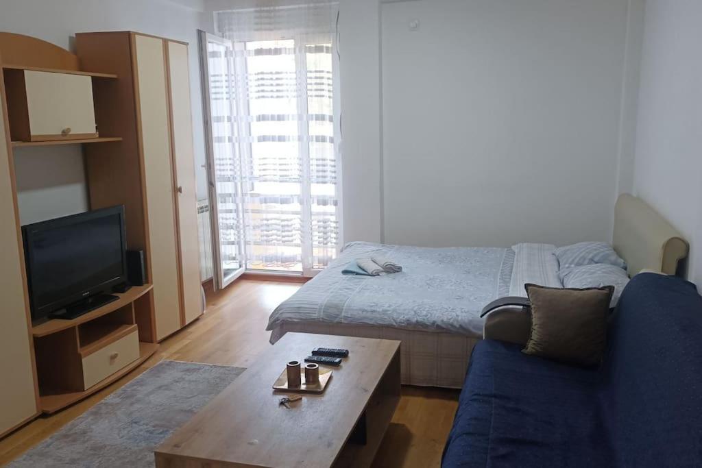 比耶洛波列Apartman Selma - Bijelo Polje的客厅配有床和蓝色沙发