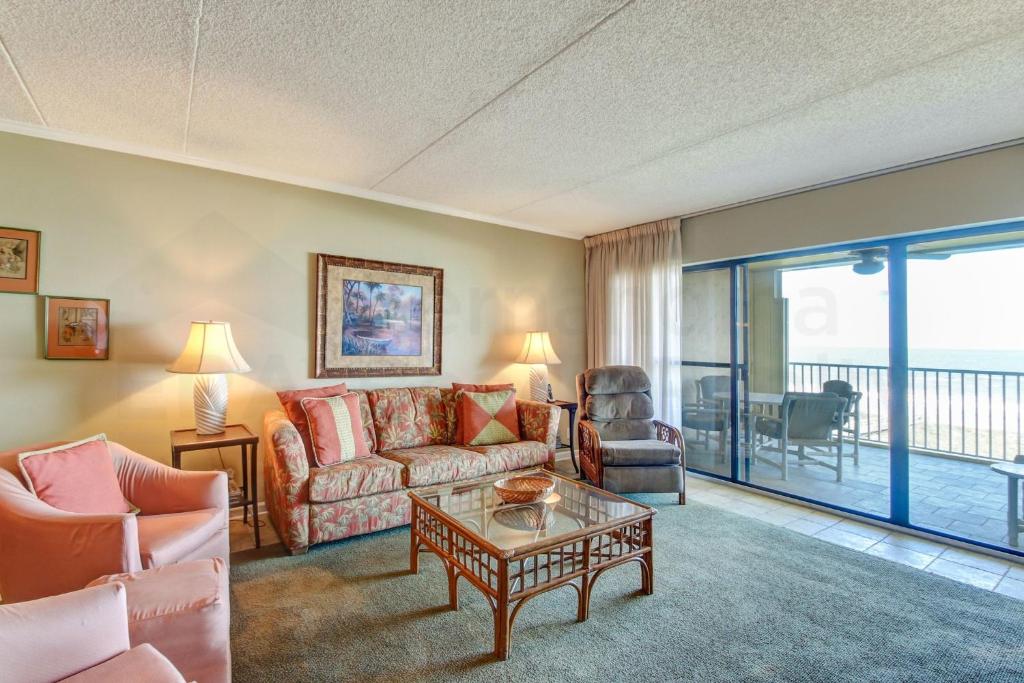 费南迪纳比奇Atlantis Oceanfront Condo的客厅配有沙发和桌子