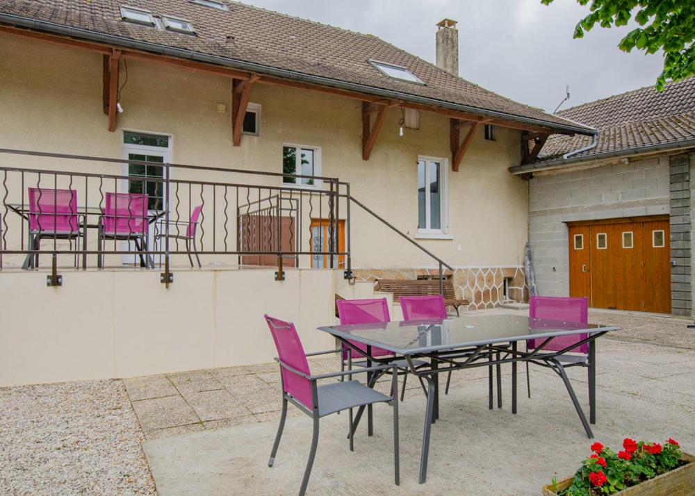 Le gite du cerf的房屋前设有带粉红色椅子和桌子的庭院