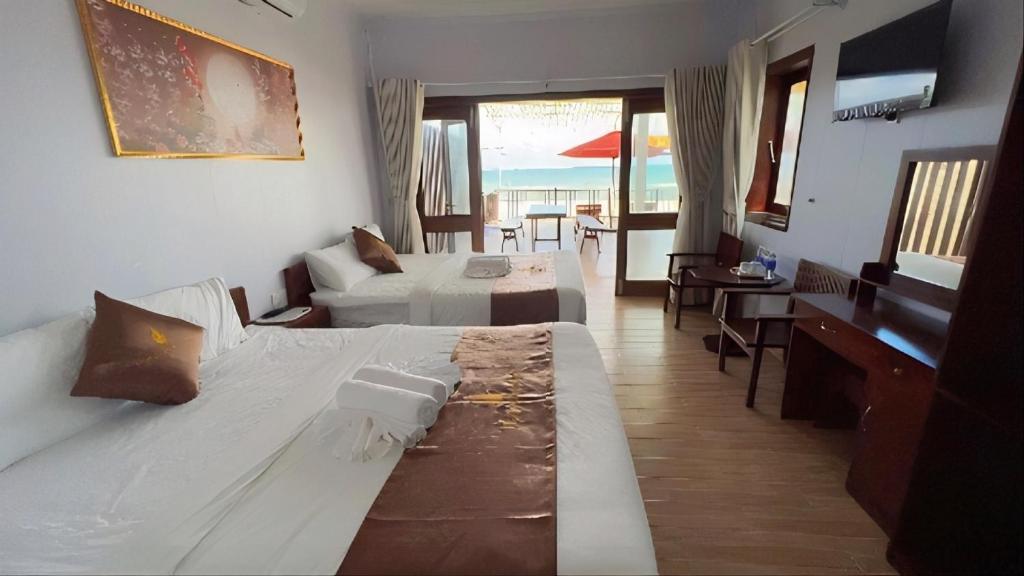 富国The Poplar Resort Phú Quốc的酒店客房设有一张大床和一张书桌。