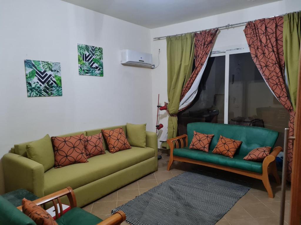 艾因苏赫纳1 bedroom unit#H101 at Lavista Topaz Alsokhna的客厅配有绿色沙发和椅子