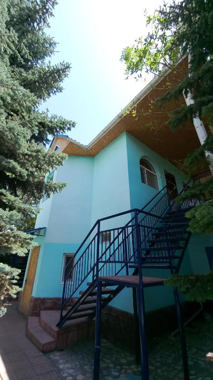 乔尔蓬阿塔гостевой дом "Бумеранг KG"的蓝色的建筑,前面有楼梯