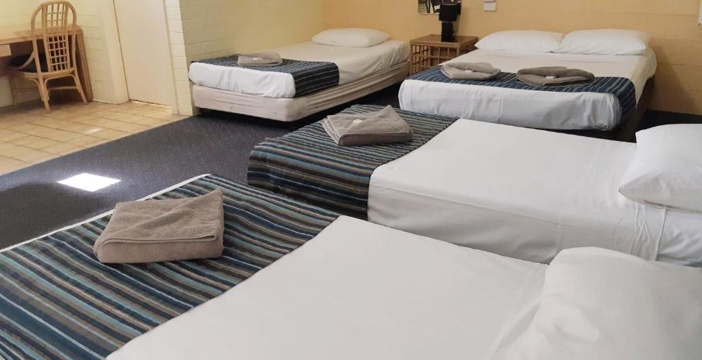 Home Hill博德金汽车旅馆的一间设有三张床的房间和一间设有三张床的房间
