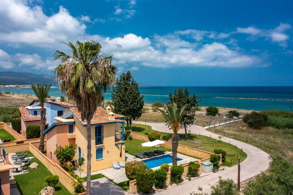波利斯The Olympians Villas的享有带游泳池和大海的房屋的空中景致