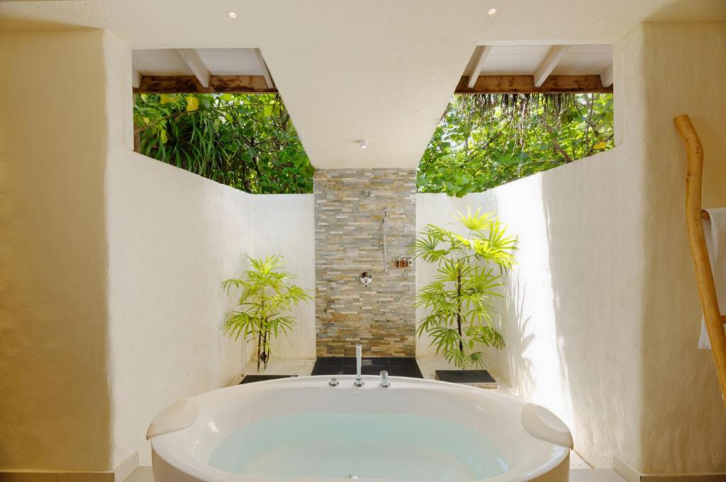 鲁阿环礁You & Me Maldives的浴室内种植了植物,配有白色浴缸。