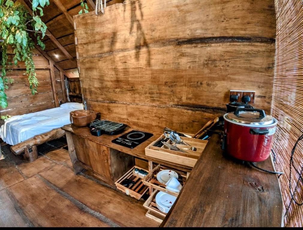 贝里胡罗亚Kale Cottage Belihuloya的一间带炉灶的厨房和一张位于客房内的床。