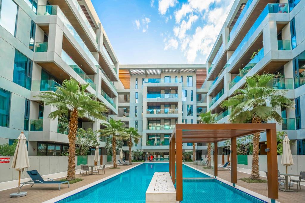 迪拜FAM Living City Walk - Opposite City Walk Mall - 2A的一座带游泳池和棕榈树的建筑的图像