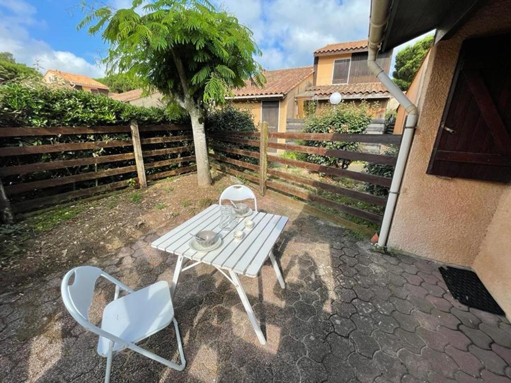 卡布勒通Maison Capbreton, 2 pièces, 4 personnes - FR-1-413-100的庭院里配有一张白色的桌子和两把椅子