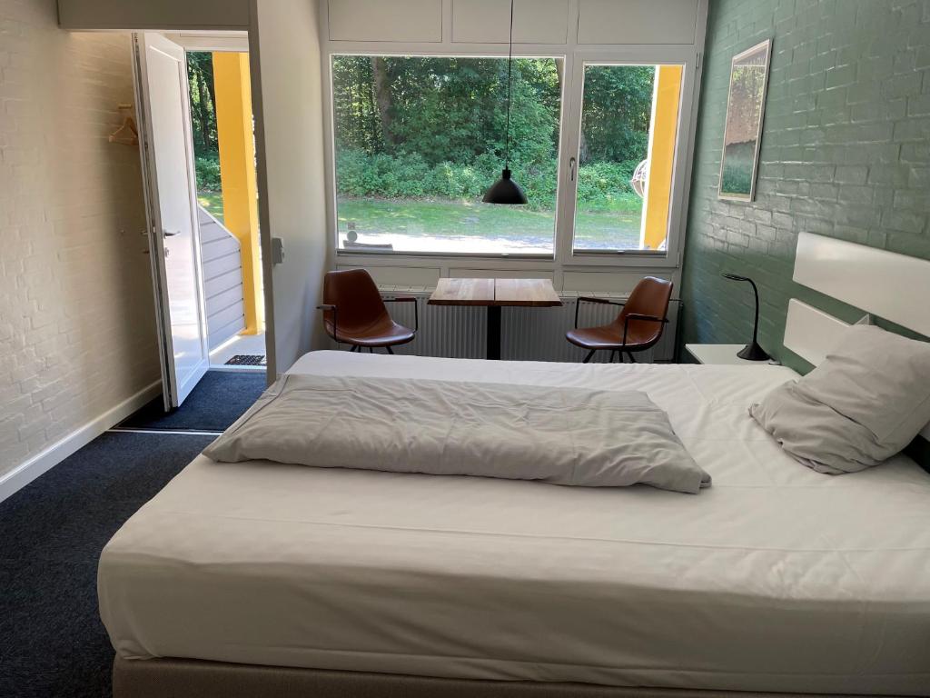 斯凯拜克Motel Rovli的卧室配有一张床和一张桌子及椅子