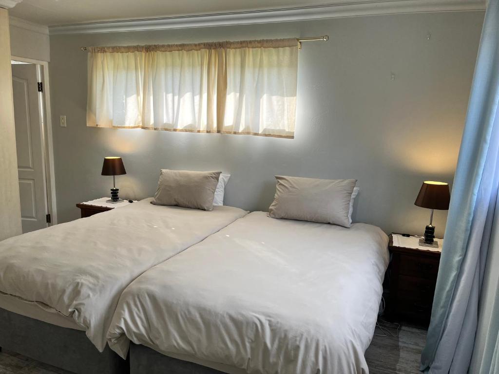 蒙塔古Dux的一间卧室配有一张带白色床单和两盏灯的床。