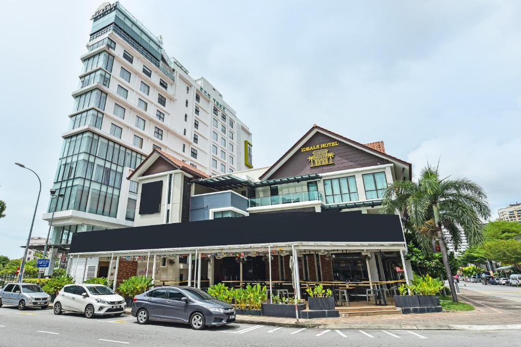 马六甲Ideals Hotel Melaka的建筑物前有车辆停放的建筑物