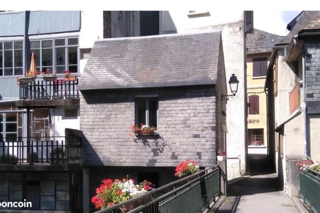 阿罗La « cabaneste » dans Arreau的一座小砖砌建筑,阳台上种有鲜花