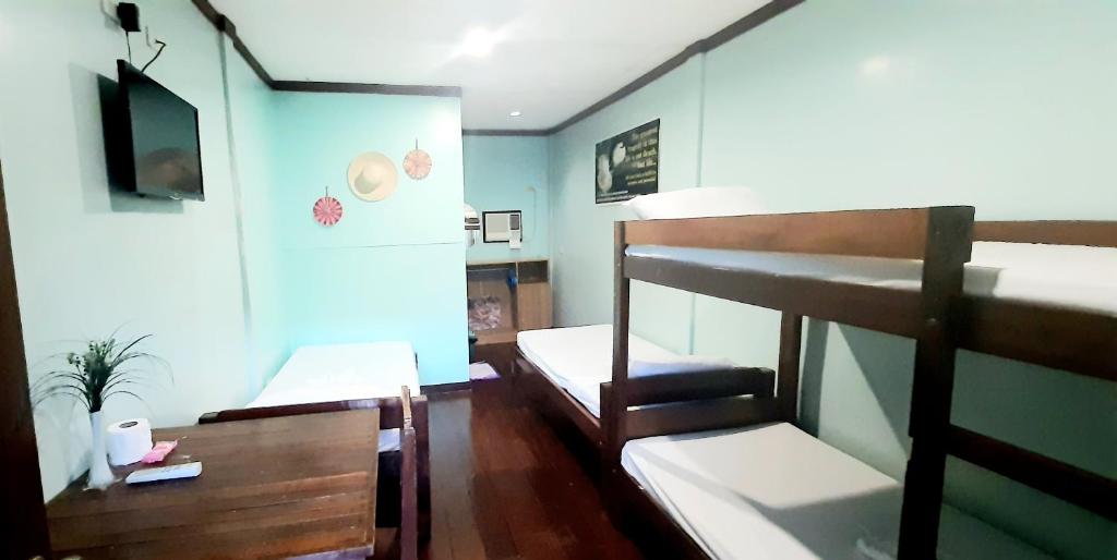 公主港Pinaluyan Guest House的客房设有两张双层床和电视。