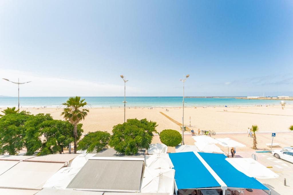 巴尔巴特Apartamento Estudio Acuario Frente Mar的海滩上设有白色的遮阳伞和海洋