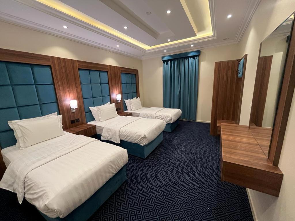艾卜哈مساكن الراحة的酒店客房设有两张床和一张桌子。