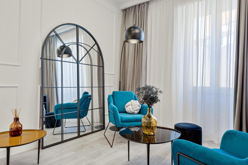 里奥马哲雷EC Luxury Rooms的客厅配有蓝色的椅子、桌子和镜子