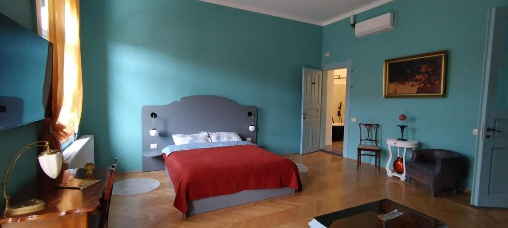 蒂米什瓦拉Melina Studio的一间拥有蓝色墙壁的卧室和一张带红色毯子的床