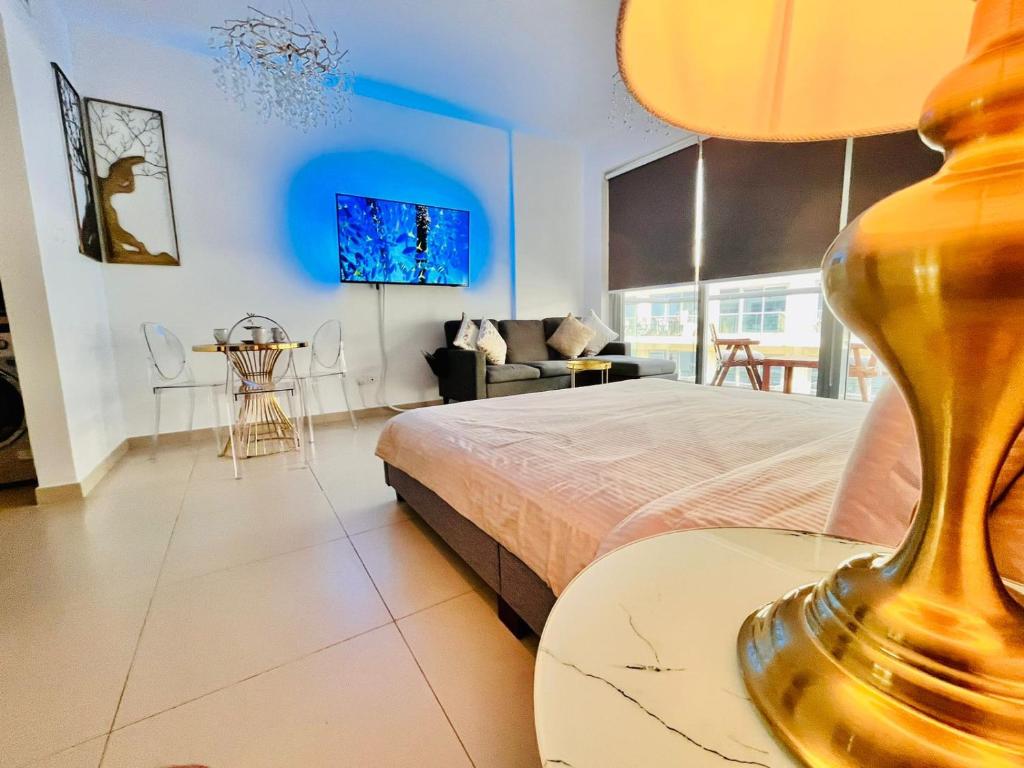 拉斯阿尔卡麦Luxurious Studio Pacific Al Marjan Island - beachfront property的一间卧室配有一张床和一张带台灯的桌子