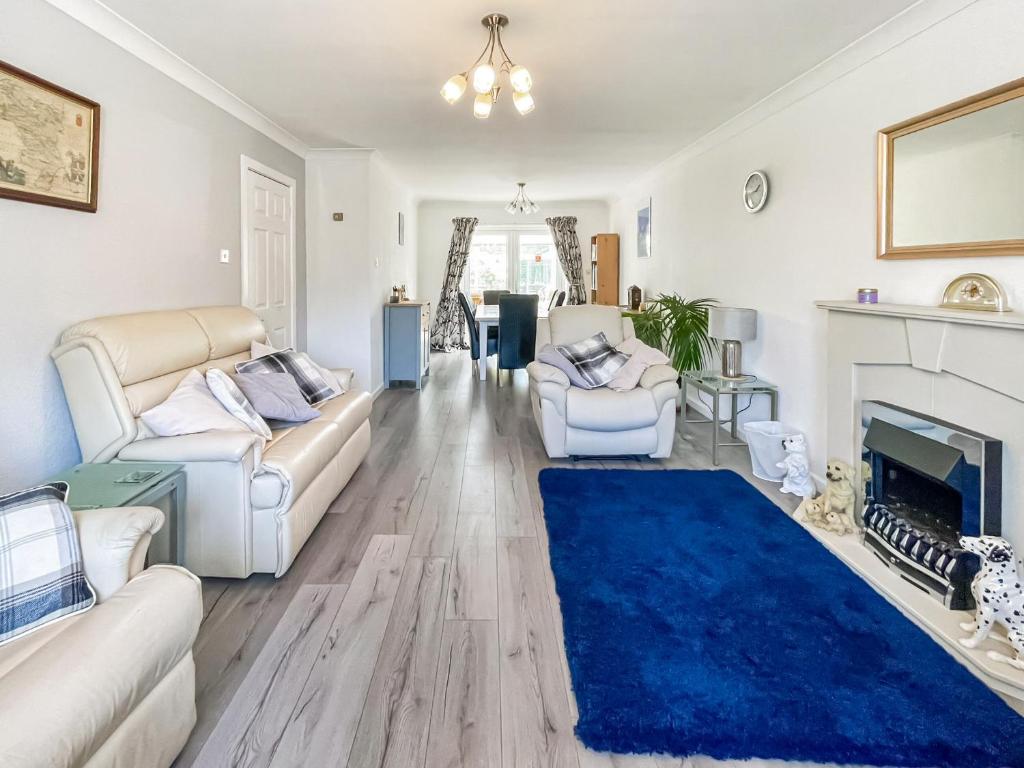 巴克斯顿Buxton Holiday Home的客厅配有白色家具和蓝色地毯。