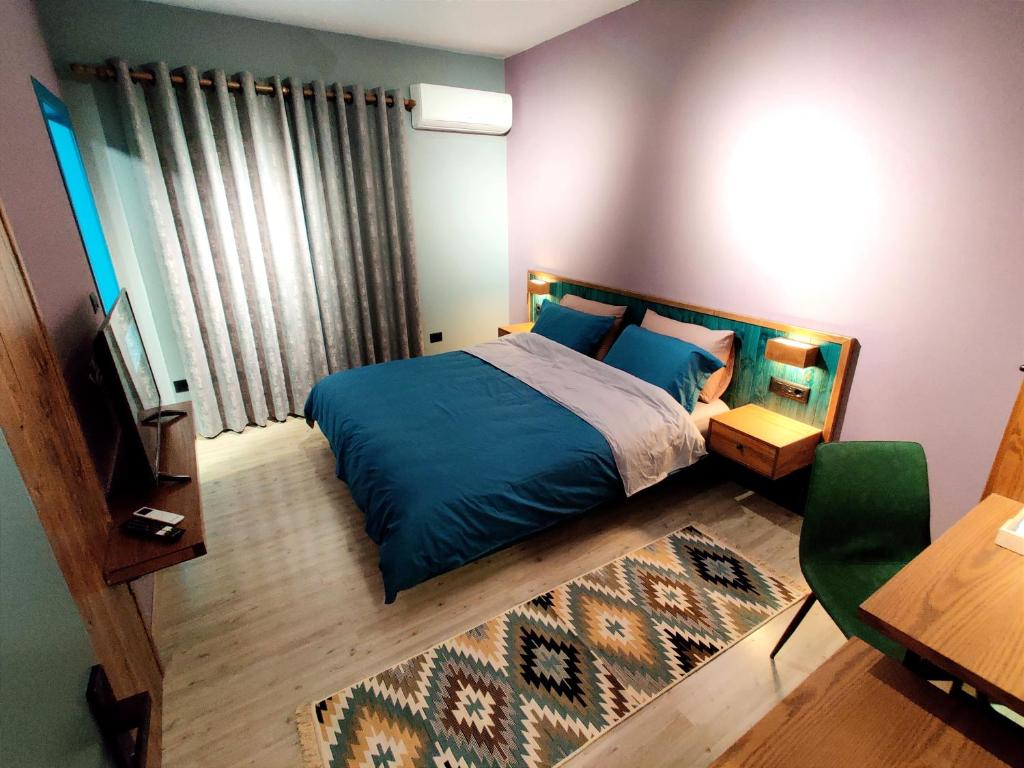 戈里察Piro's Cozy Rooms - City Centre的一间卧室配有蓝色的床和电视