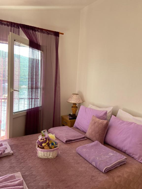 科托尔Apartment Alex的一张带紫色枕头的床和一个篮子