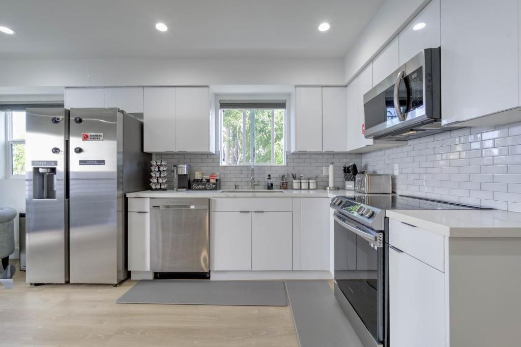 洛杉矶Modern Apartment in Studio City的厨房配有白色橱柜和不锈钢用具