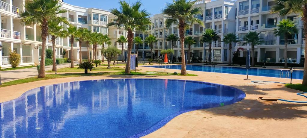 布兹尼盖Bouznika plage costa的大楼前的大型蓝色游泳池
