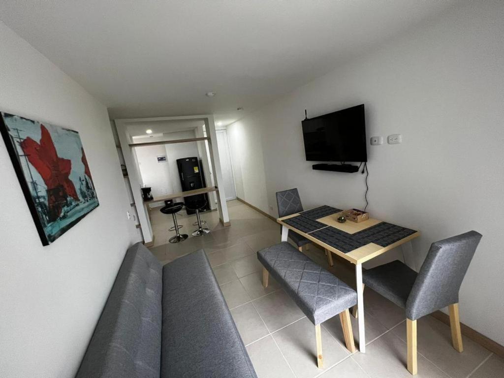 马尼萨莱斯Hermoso apartamento la Francia 3 habitaciones的客厅配有桌椅和电视。