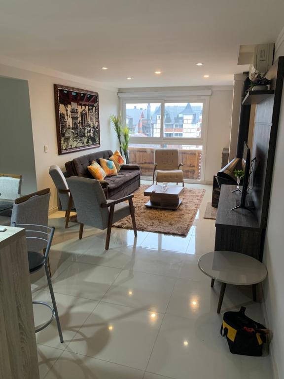 卡内拉Apartamento Gramado/Canela的客厅配有沙发和桌子