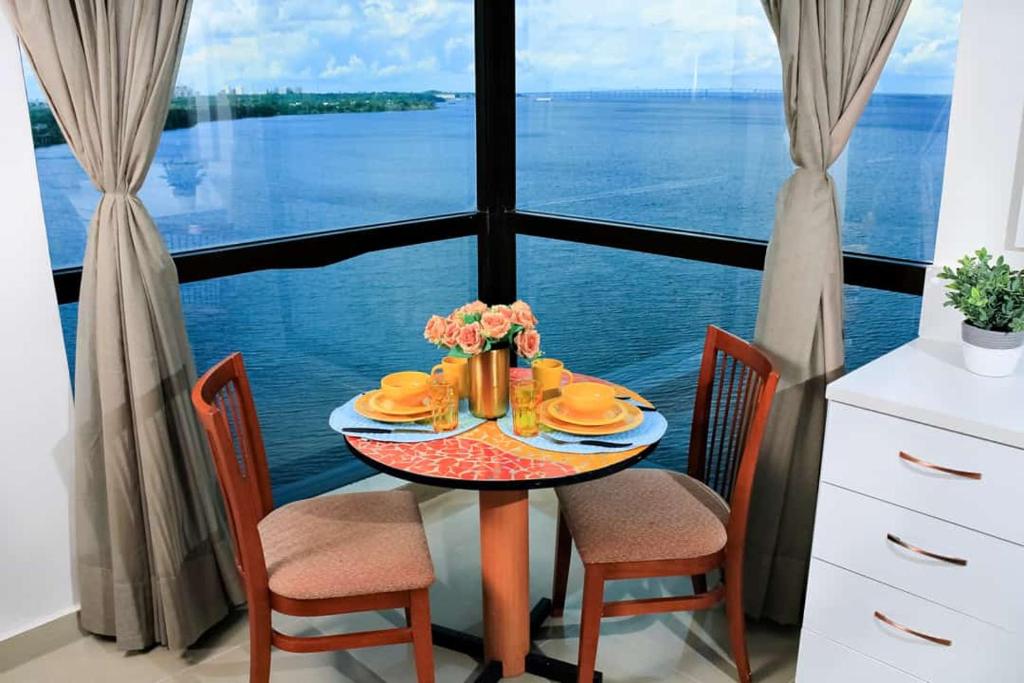 马瑙斯Tropical Executive 1305 with VIEW的一张桌子,上面放着一盘食物,享有水景