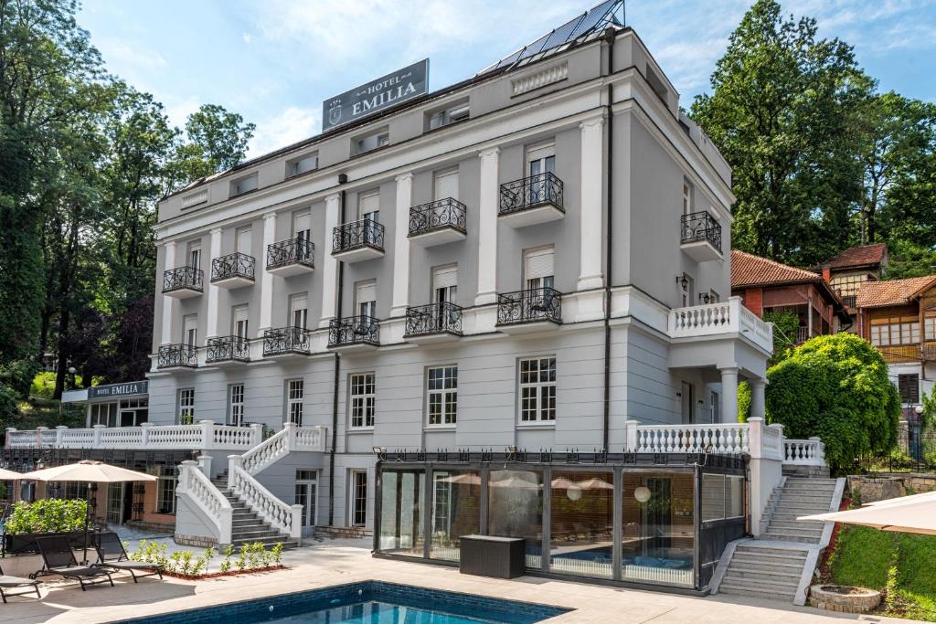 弗尔尼亚奇卡矿泉镇Emilia Lux Rooms的前面有一个游泳池的酒店