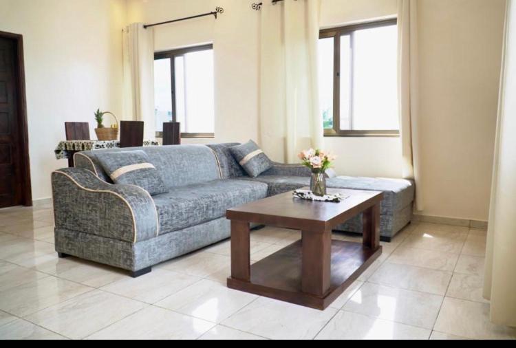科托努Résidence des Amazones Appartement 2的带沙发和咖啡桌的客厅