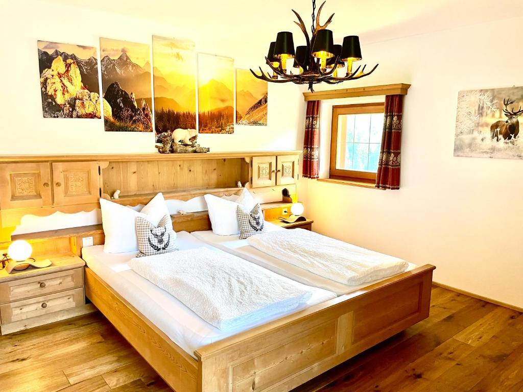 奥蒂塞伊Chalet Bernardi Apartments的一间卧室配有一张大床和一个吊灯。