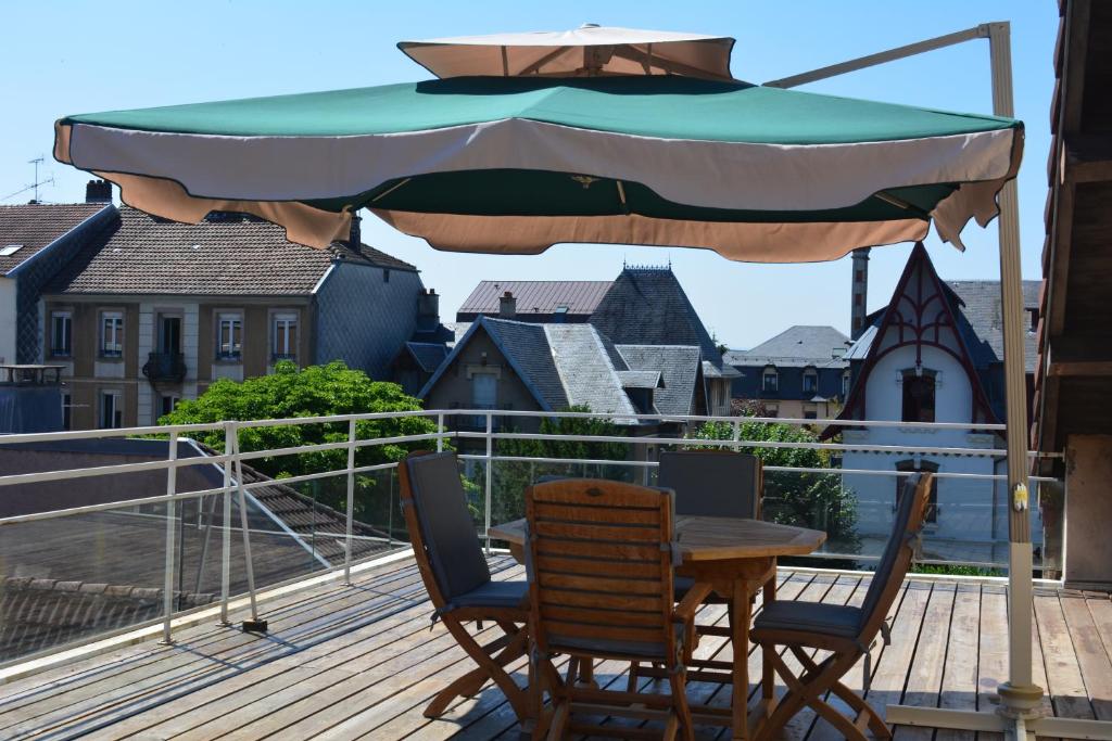 贝尔福Appartement-terrasse parking privé Meublé de Tourisme 4 étoiles的甲板上遮阳伞下的桌椅